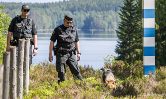 Kaksi rajavartijaa ja koira Suomen itärajalla.