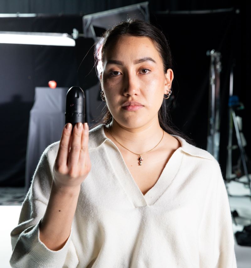 Valkoiseen paitaan pukeutunut Leidy Cadena pitelee kädessään mustaa kumiluotia.