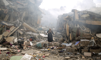 Ihminen seisoo tuhottujen rakennusten keskellä.