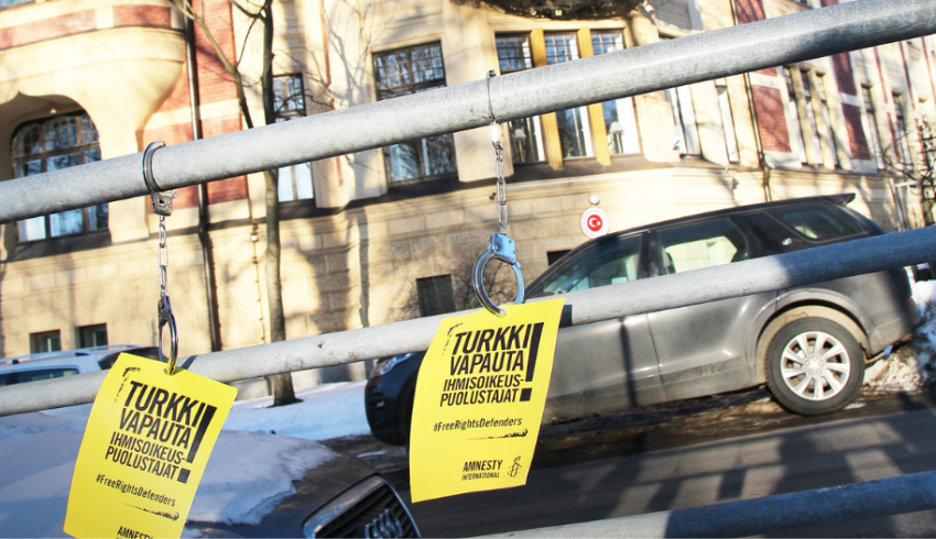 Keltaisia lappuja kiinnitettynä kaiteeseen.