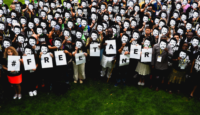 Ryhmä ihmisiä, joilla kaikilla on samanlainen paperinen naamio kasvoillaan.