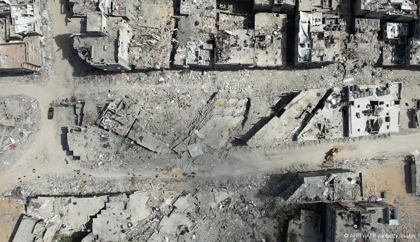 Puskutraktori raivaa raunioita Israelin iskuissa tuhottujen rakennusten keskellä.