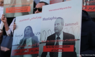 Ihmiset pitelevät mielenosoituskylttejä.